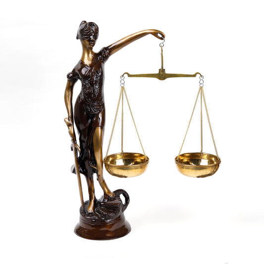 A brass figurine of the Justice Lady with a scale and sword in her hands, standing on a snake, with an antique brown finish.