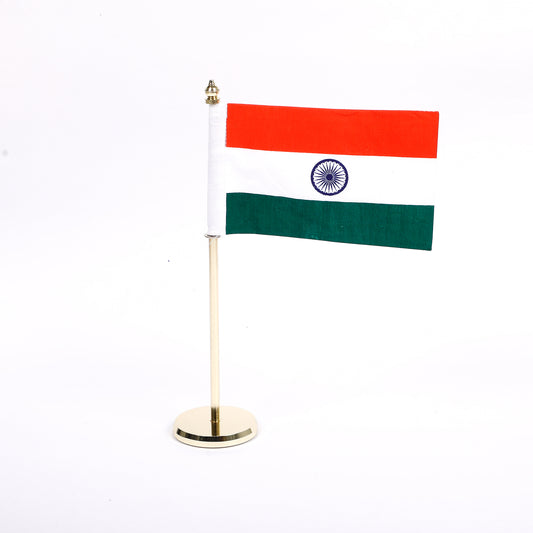 A table top national flag with a golden metal pole and a tricolor flag attached to it, displayed against a white background.