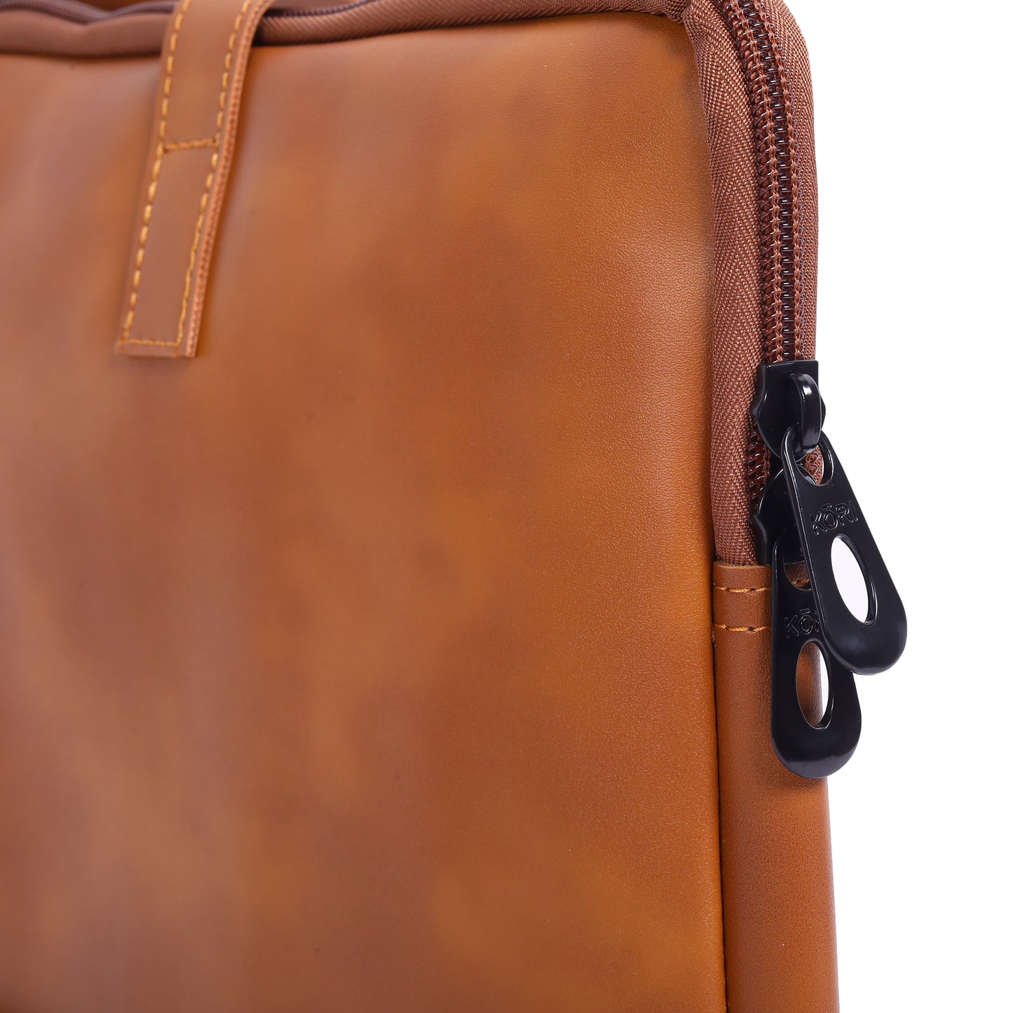 Close-up of a brown leather bag with a zipper pull.
