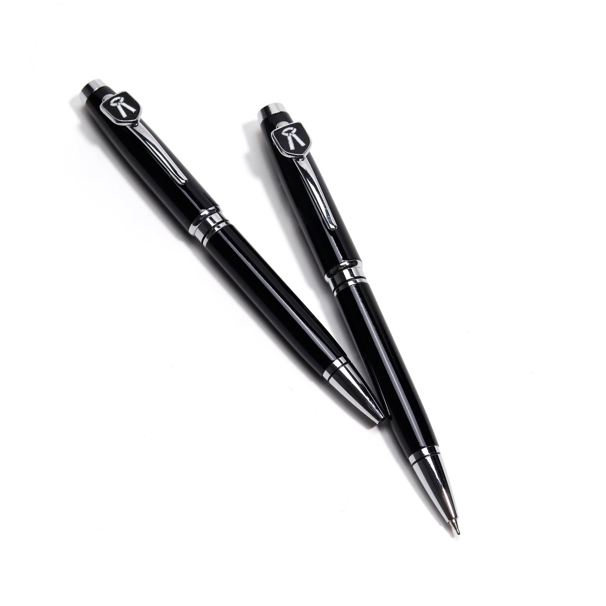 Two black pens with silver accents on a white background